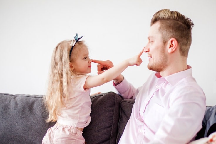 El padre y la niña se tocan la nariz con la mano - La disciplina efectiva crea una estrecha relación padre-hijo, beneficios de la disciplina. La disciplina no es lo mismo que el castigo.