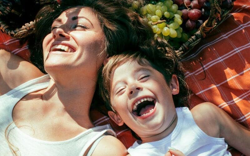 mamá riendo con un hijo de tres años después de un horario de sueño de tres años 